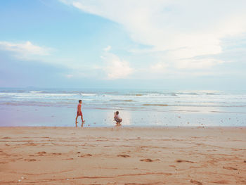 Happy romantic couple enjoying beautiful sunset walk on the beach. pastel colors tone