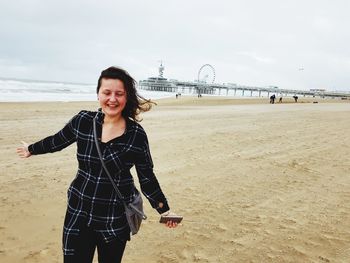 Portrait of smiling young woman standing on beach