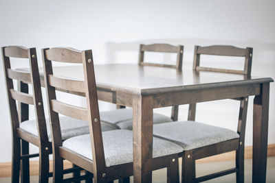 Close-up of empty chairs and table against sky