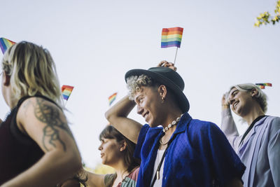 Smiling young man enjoying with friends during lgbtqia rights parade