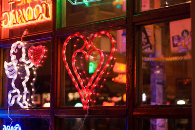 Close-up of illuminated text on glass window at night