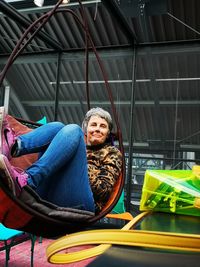 Portrait of smiling mature woman sitting on hammock