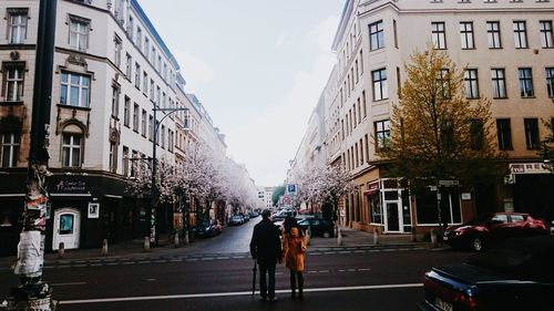 Couple walking on road along built structures