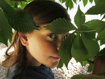 Close-up portrait of girl amidst leaves