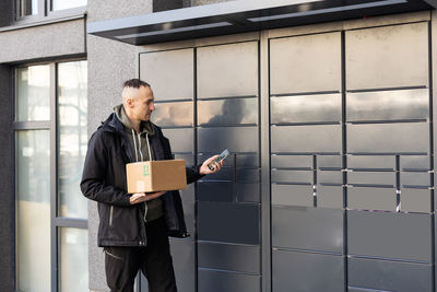 Storage units reservation. rental storage units on internet. man with smartphone chooses warehouse