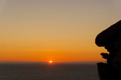 Scenic view of sea against orange sky