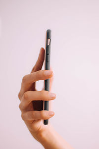 Close-up of person holding guitar against white background