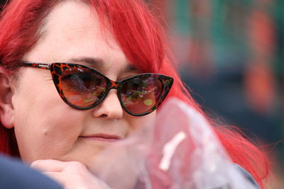 Close-up of mature redhead woman wearing sunglasses
