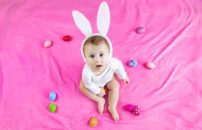 High angle view of cute girl playing with toys on bed