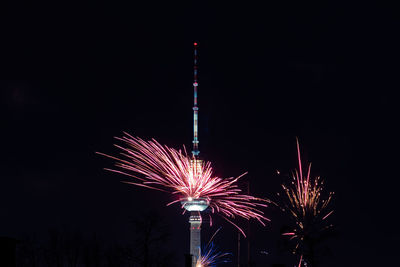 Low angle view of firework display at night