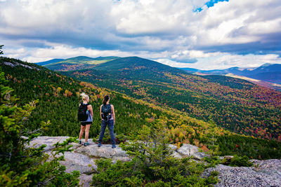 People standing on mountain against sky