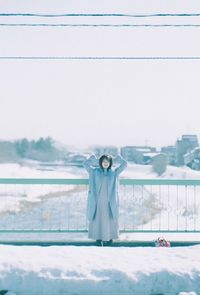 Portrait of person standing on snow covered field