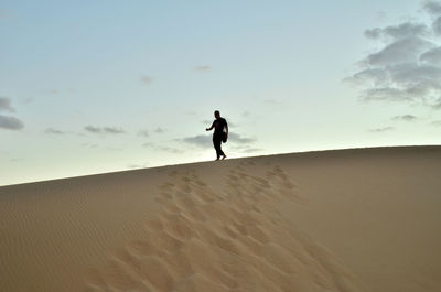 Full length of man on sand at beach against sky