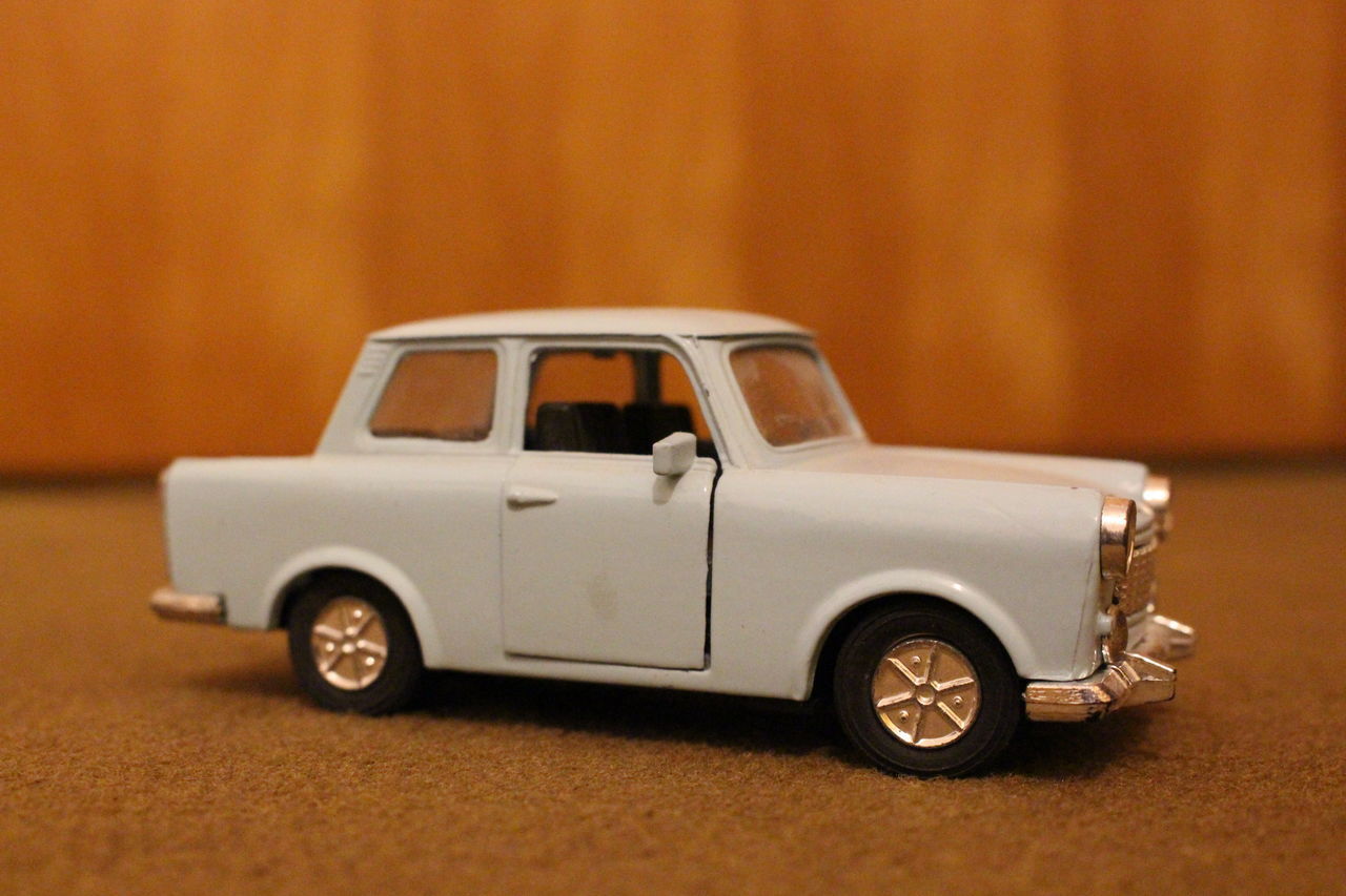 CLOSE-UP OF TOY CAR ON TABLE BY WALL