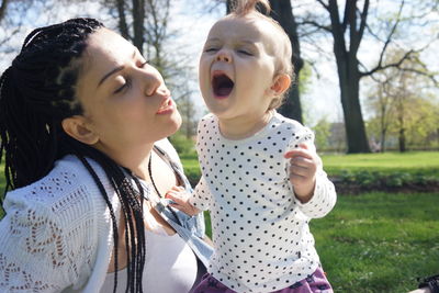 Portrait of happy woman and baby girl in park