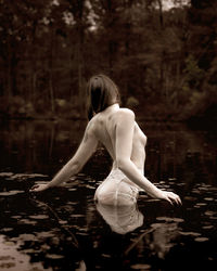 Rear view of woman with reflection in lake