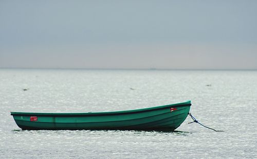 Boat moored on sea against sky