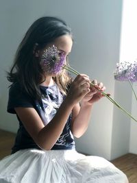 Midsection of woman holding purple flower