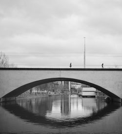 Arch bridge over river against sky
