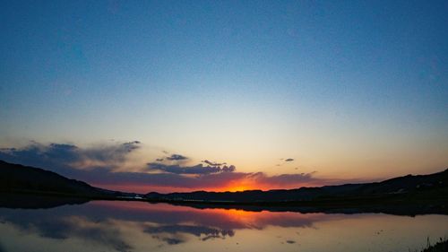 Scenic view of lake against romantic sky at sunset