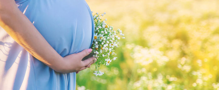 Midsection of woman with hand on stomach