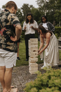 Friends playing jenga in garden