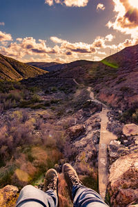 Low section of person on mountain against sky