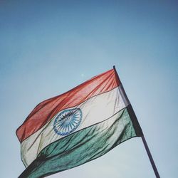 Low angle view of flag against clear blue sky