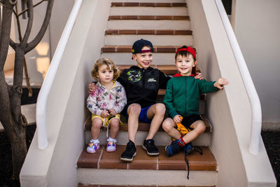 High angle view of siblings sitting on steps