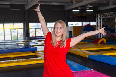 Happy young woman with arms raised