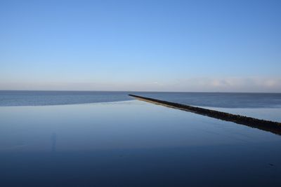 Scenic view of sea against clear blue sky