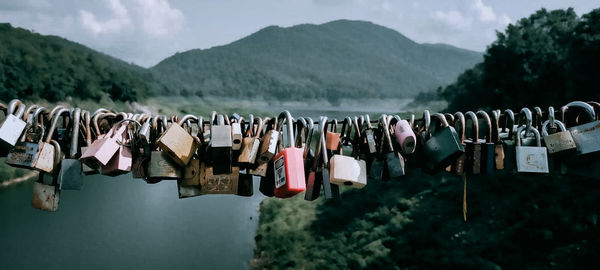 Padlocks hanging on metal against mountains