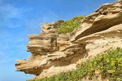 Low angle view of rock formation against sky