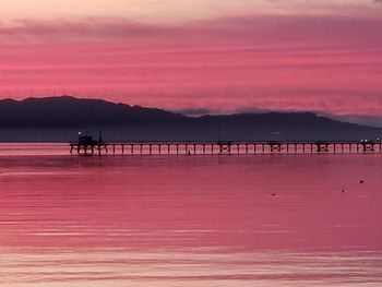 Pier over sea against sky during sunset