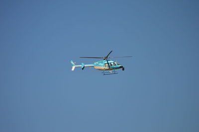 Low angle view of airplane against clear blue sky