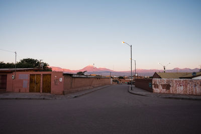 Street amidst buildings against sky at dusk