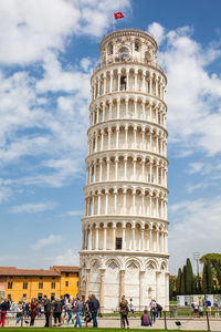 Tourists at the leaning tower of pisa in a beautiful early spring day