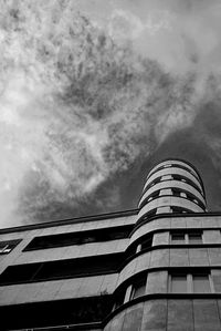 Low angle view of modern building against cloudy sky