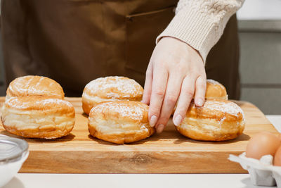 Woman prepares fresh donuts with jam in home kitchen. cooking traditional jewish hanukkah sufganiyot