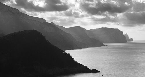 Scenic view of sea and mountains against sky