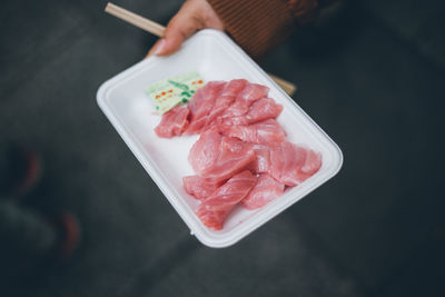 Close-up high angle view of hand holding sashimi