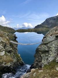 Suspension bridge in front of a mountain lake