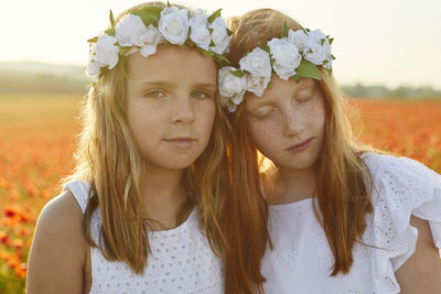 Portrait of girls in poppy meadow