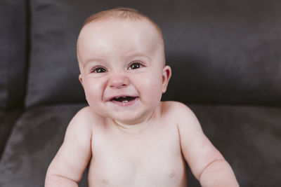 Cute baby boy smiling on sofa at home