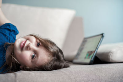 Portrait of girl lying on sofa at home