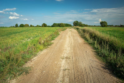 Dirt road along countryside landscape