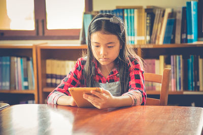 Full length of girl sitting on table