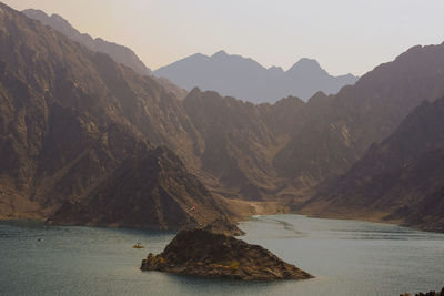 Scenic view of sea and mountains against sky