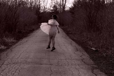 Rear view of woman walking on footpath