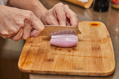 Cropped hands of man preparing food on cutting board